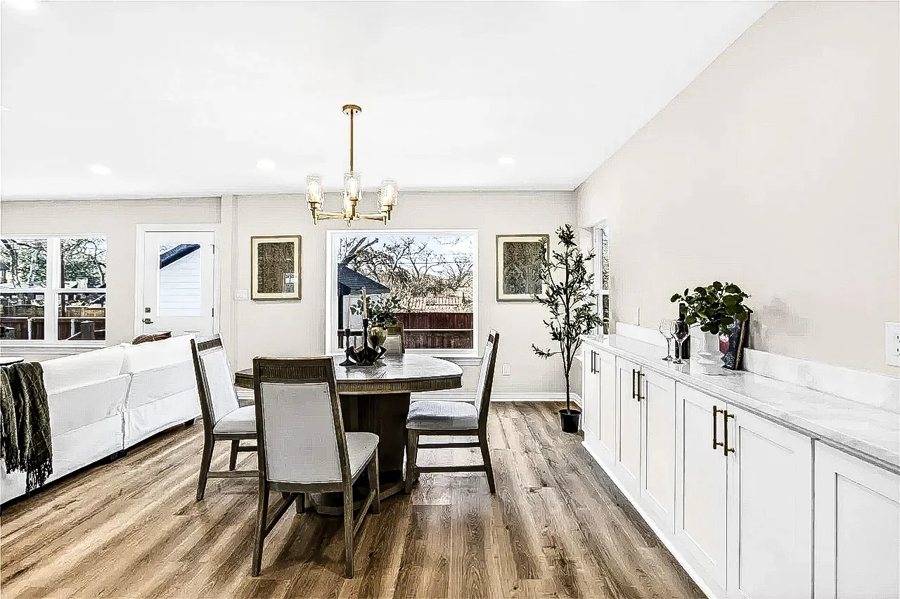 Lakewood dining room with white built-in cabinetry, wood counters, black-framed windows, and brass chandelier.