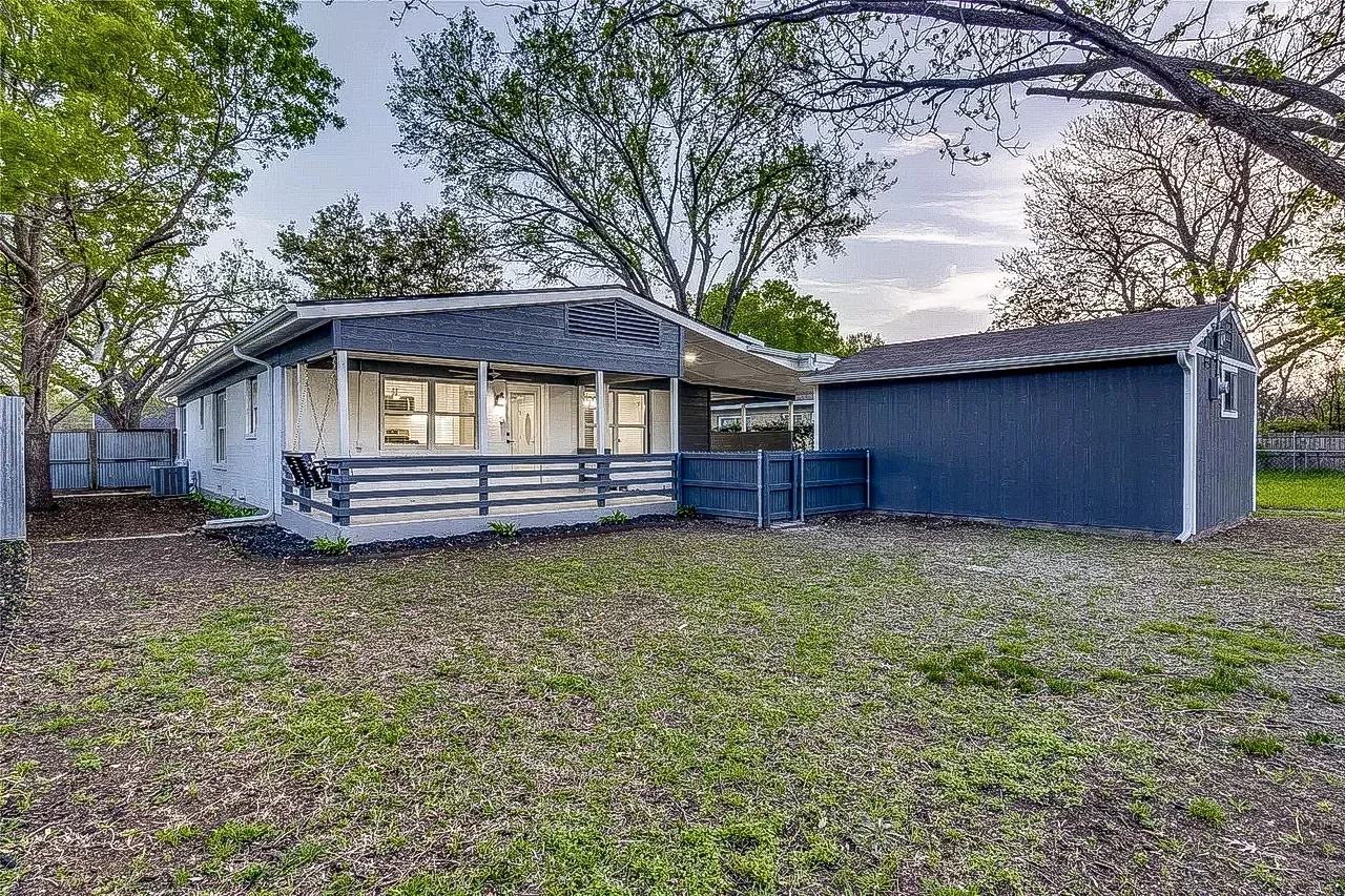 Dallas ranch home exterior with blue-gray painted siding, dark roof, porch, and open yard.