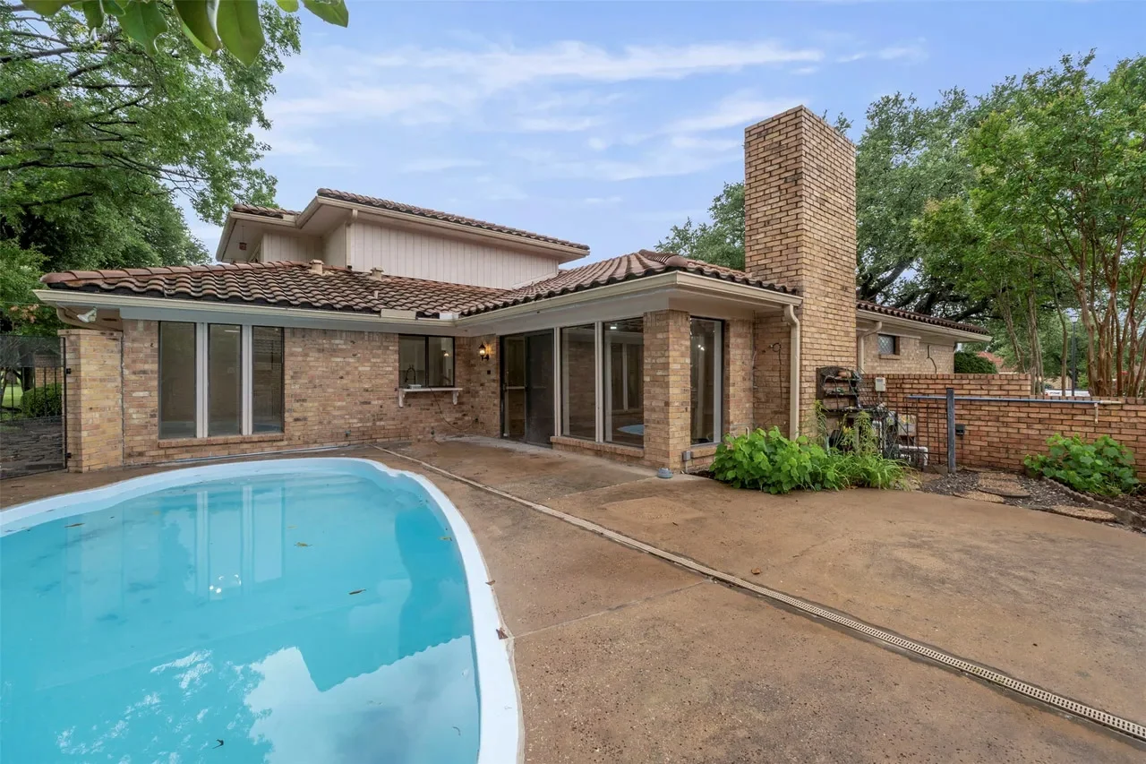 Brick Fort Worth home beside the pool with refreshed exterior surfaces, windows, and covered outdoor areas in Fort Worth, Texas.
