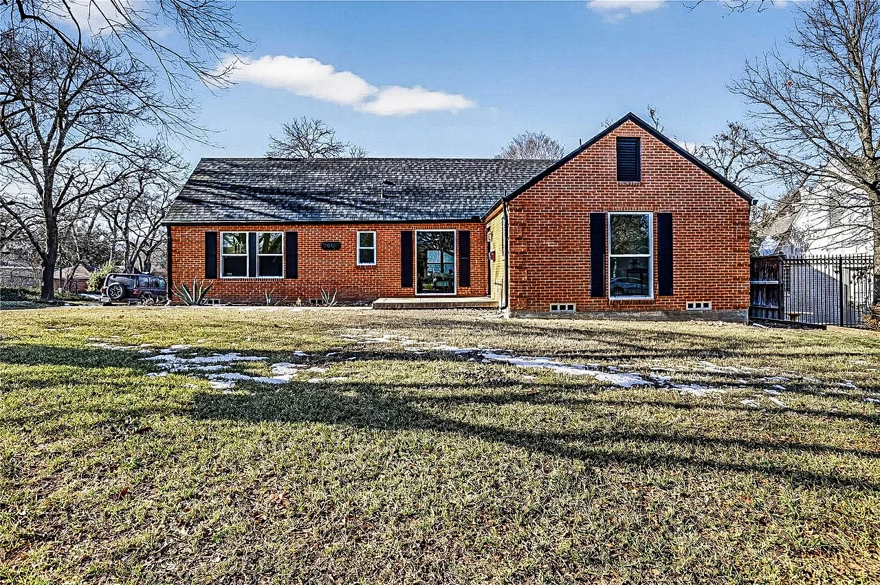 Red brick Lakewood home with black replacement windows, dark roofing, and a winter front yard in Lakewood, Dallas, Texas.