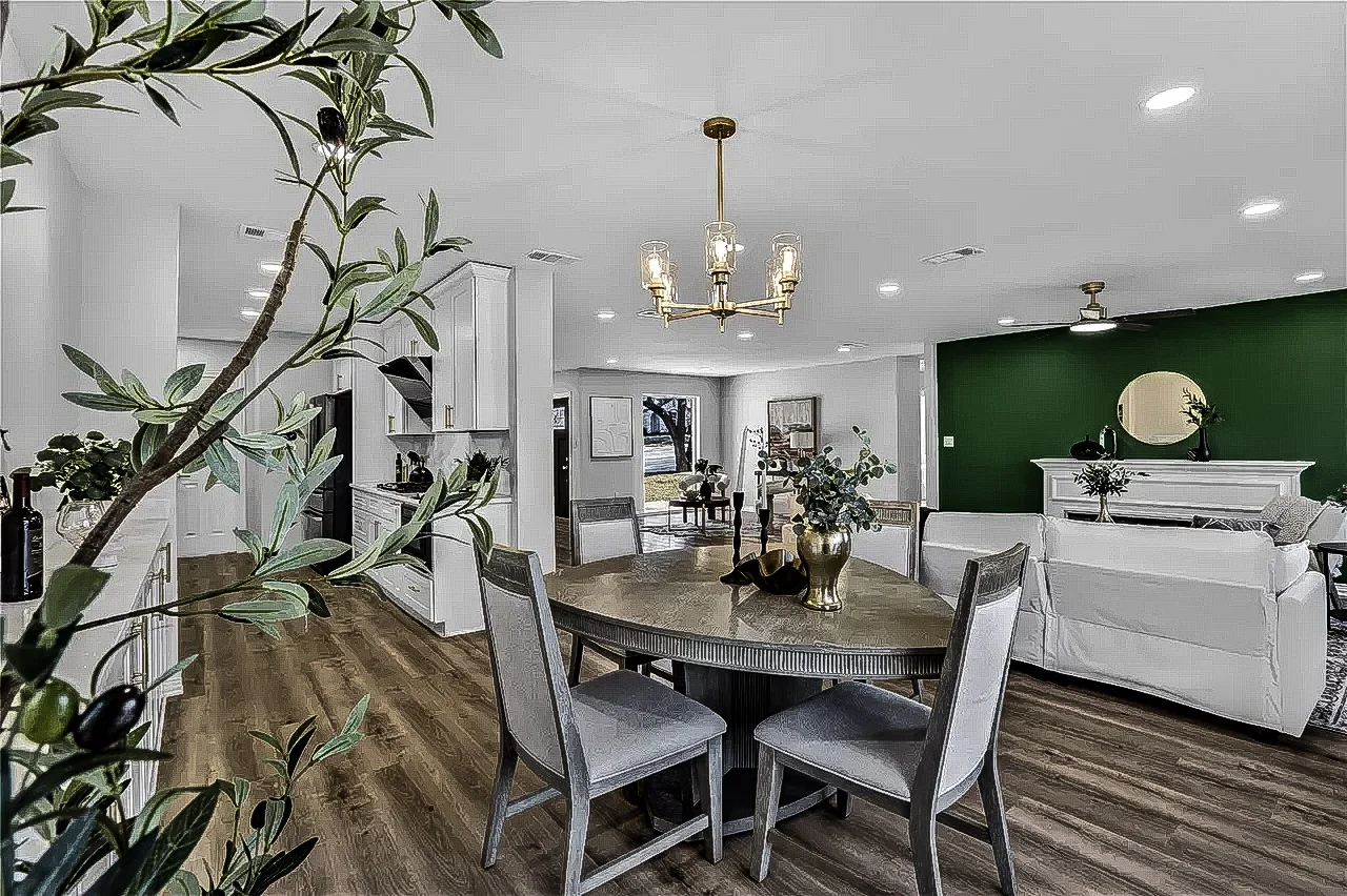 Wide dining and living view with a deep green accent wall, custom built-ins, white cabinetry, and light wood-look flooring in Lakewood, Dallas, Texas.