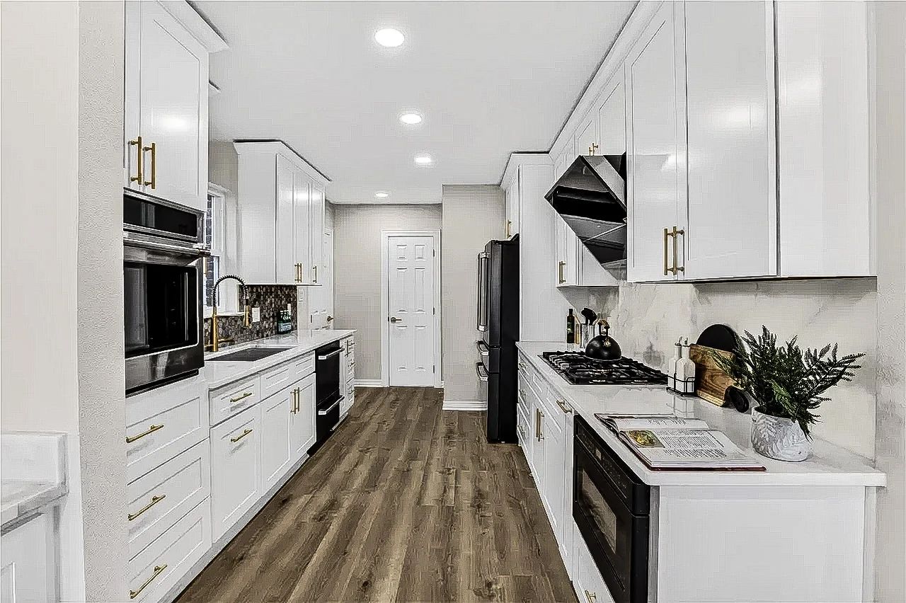 White shaker kitchen with black appliances, brass hardware, stone counters, patterned backsplash, and light wood-look flooring in Lakewood, Dallas, Texas.