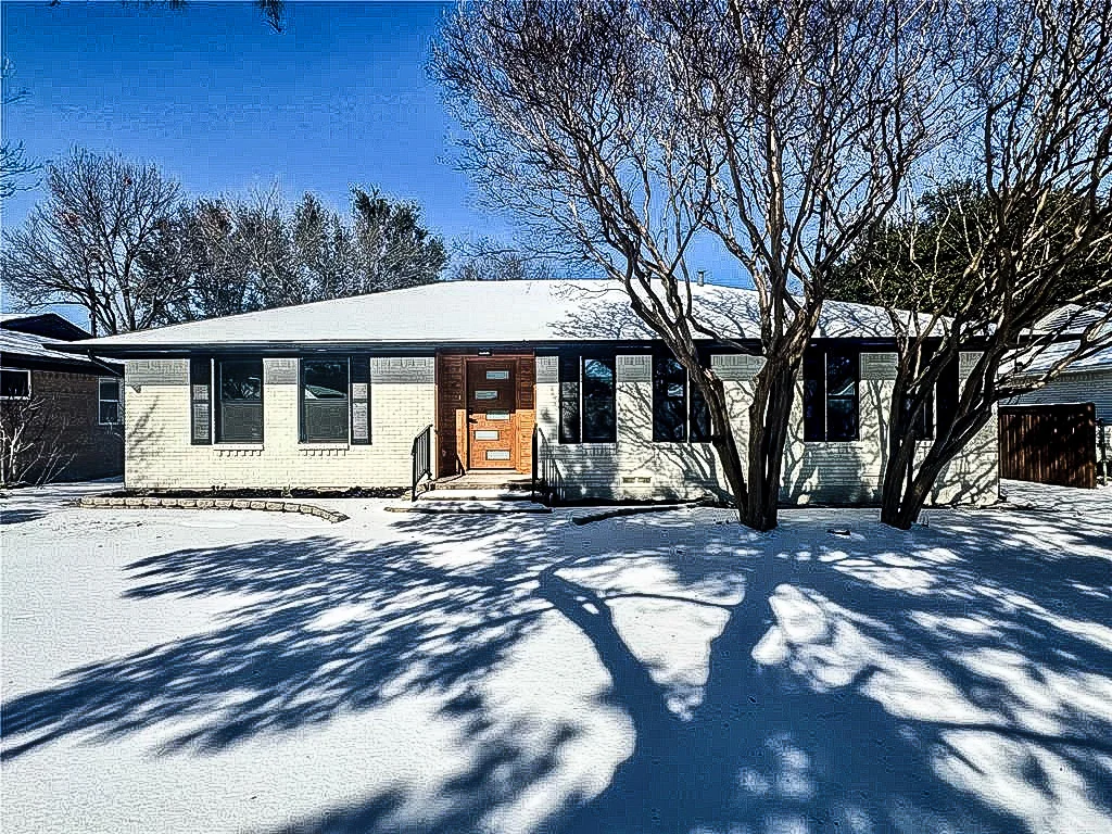 White brick Lower Greenville home with black replacement windows, modern wood front door, and winter landscaping in Lower Greenville, Dallas, Texas.