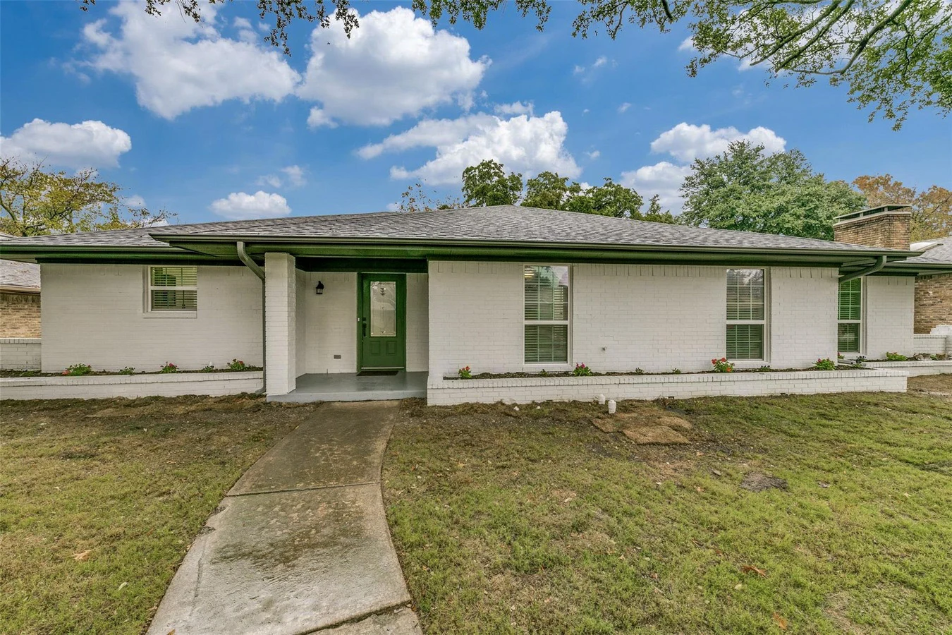 Single-story Plano exterior with replacement windows, fresh neutral paint, dark trim, and a green front door in Plano, Texas.