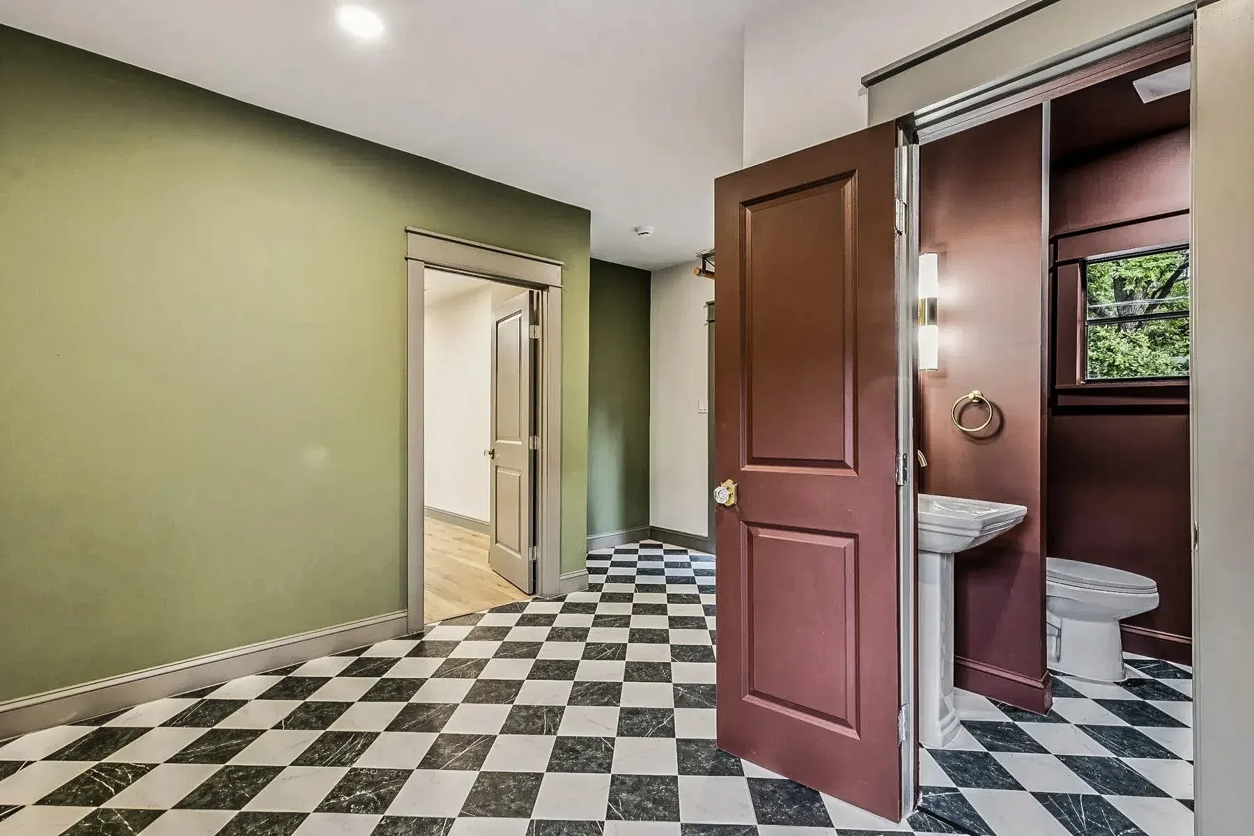 Dallas utility hallway with black-and-white checkerboard tile flooring, dark trim, and adjoining powder room.