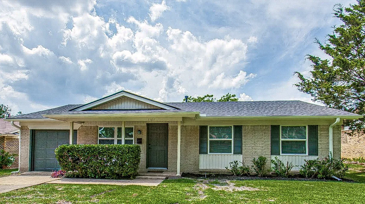 Dallas ranch home with replacement windows, light brick exterior, dark shutters, and green lawn.